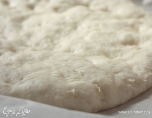 Подошедшее тесто выложите на теплый противень, застеленный бумагой для выпечки, накройте полотенцем и снова оставьте на 20-30 минут.