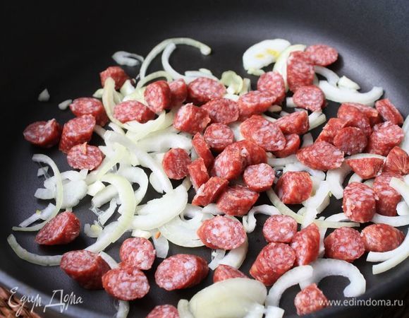 Охотничьи колбаски нарежьте на кусочки и вместе с луком пассеруйте на среднем огне в течение 7-10 минут.