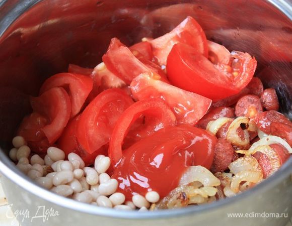 Помидоры нарежьте дольками (они нужны больше для фактуры). В кастрюлю выложите обжаренные с луком колбаски (и не забудьте оставшийся от жарки сок), помидоры, фасоль и пассату из протертых помидоров (или томатный соус). Залейте все ингредиенты куриным бульоном и тушите на среднем огне до готовности фасоли. 