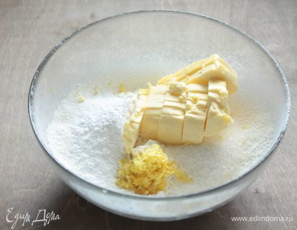 Сначала сделаем песочное тесто. Возьмите холодное сливочное масло, просейте муку, добавьте сахар и лимонную цедру и разотрите все ингредиенты в крупную крошку. Можно также порубить их ножом.