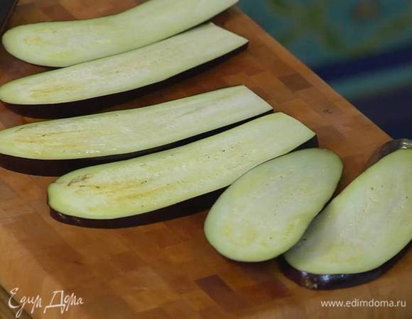 Баклажан нарезать вдоль пластинками, сбрызнуть со всех сторон оливковым маслом и обжаривать на сковороде-гриль до появления румяных полосок.