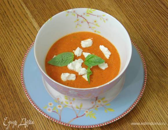 Разлить суп в тарелки, сверху разложить разломленный на кусочки козий сыр, украсить листьями базилика.