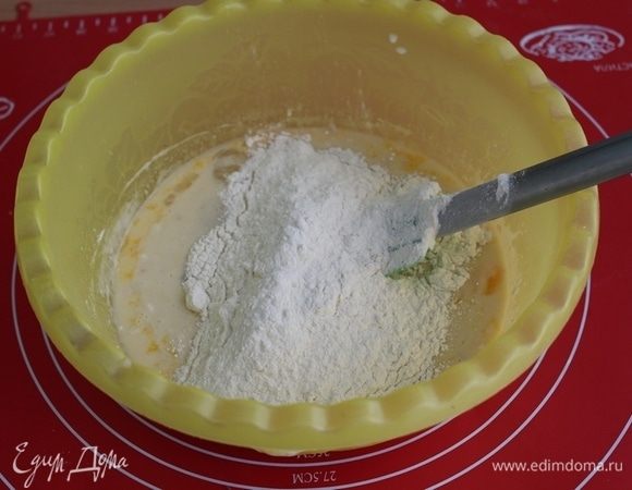 Добавить часть просеянной муки, перемешать лопаткой.