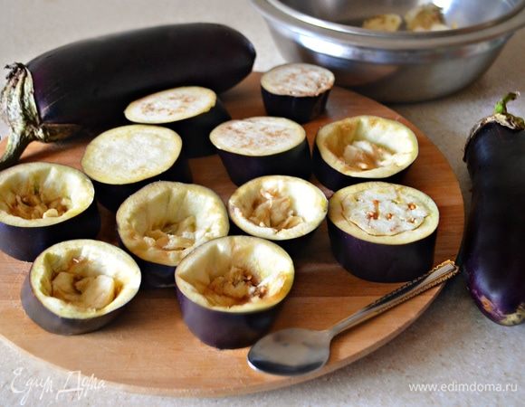 Два небольших баклажана вымыть, обсушить, нарезать кружочками толщиной 1,5-2 см.  Аккуратно с помощью ложки вынуть мякоть, оставляя стенки и дно толщиной 5 мм. Посыпать баклажаны солью, дать постоять около 15 мин. и промыть холодной водой.