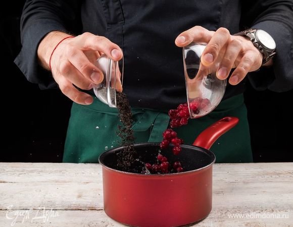 Засыпать в сотейник черный чай и клюкву.