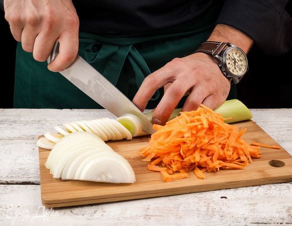 Нарежьте полукольцами репчатый лук и белую часть лука-порея, морковь очистите и натрите на терке. 