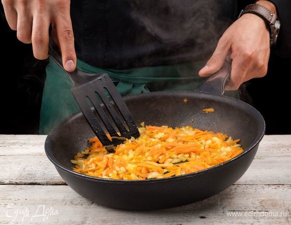 В сковороде пассеруйте на оливковом масле лук до золотистого цвета, дальше добавьте морковь и чеснок.