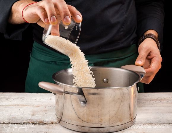 В кастрюлю с горячим бульоном добавьте рис. 