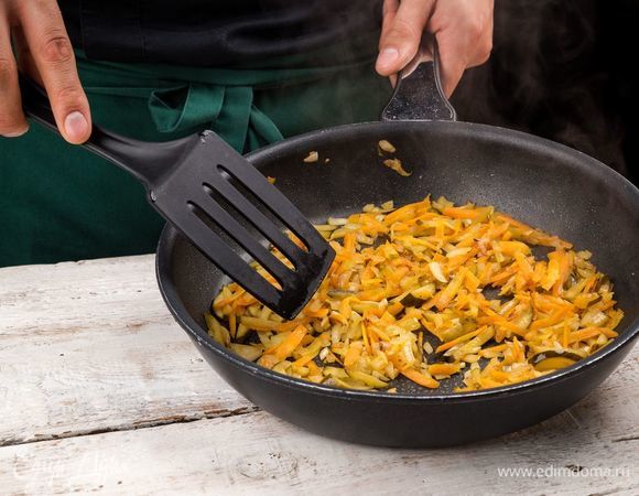 Тушите на оливковом масле лук, морковь, маслины, огурцы до золотистого цвета.