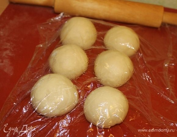 Подошедшее тесто разделите на шесть равных частей. Каждую часть скатайте в шарик, накройте пленкой и оставьте на 10-15 минут отдохнуть.