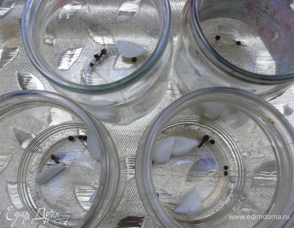 В чистые банки положите чеснок порезанный, перец, гвоздику.