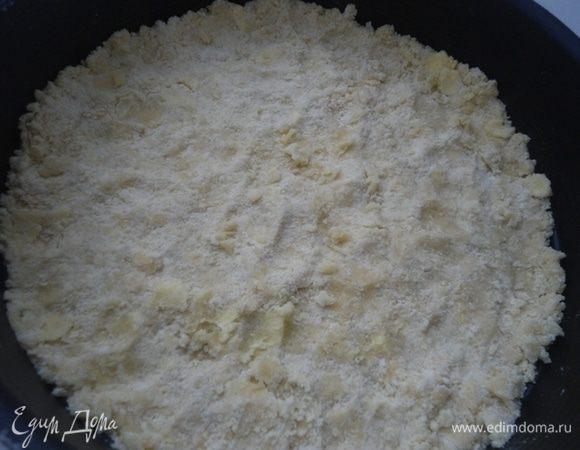 Половину крошки распределить по форме 26 см, слегка прижимая пальцами ко дну.