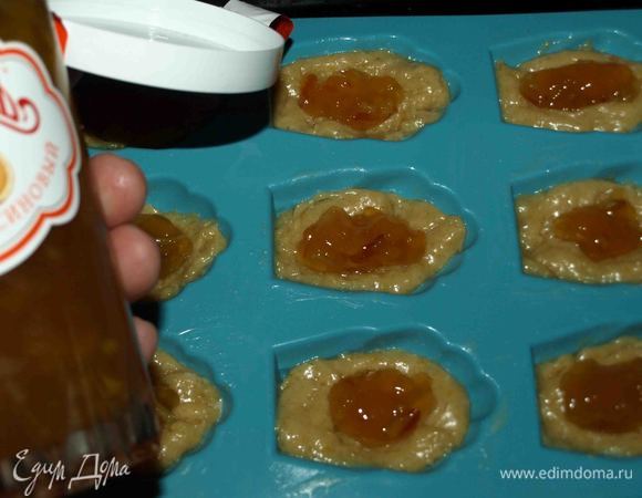 Раскладываем в формочки. Наполняем каждую форму на 3/4. Сверху выкладываем апельсиновый джем ТМ «МахеевЪ». Стараться, чтобы джем не прикасался к стенкам формы, а был именно в центре теста.