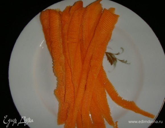 Для украшения торта морковь почистить и нарезать овощечисткой на тонкие, длинные полоски.