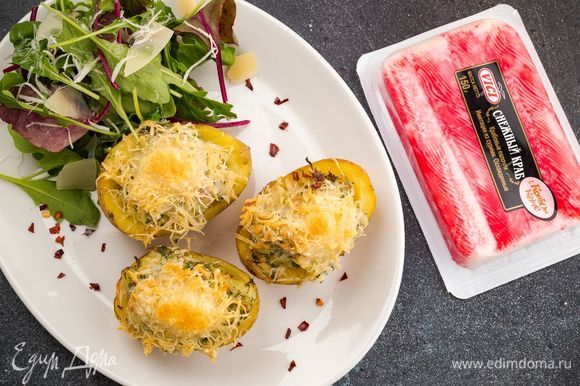 На тарелку выложите листья салата, запеченный картофель с крабовыми палочками и ароматной сырной корочкой. Приятного аппетита!