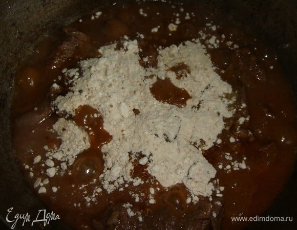 Через 40 минут в казан добавить лавровый лист и муку. Все хорошо перемешать и тушить еще 10 минут.