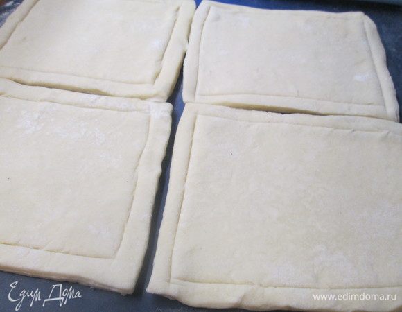 Пока обжаривается карп, разморозить тесто. Стол присыпать мукой и раскатать тесто в пласт, толщиной 0,5 см.
Разрезать его на квадраты 10х10 и на каждом из них ножом слегка наметить контур, отступив от края 5-7 мм. Перед отправкой в духовку смазать квадраты желтком.
Запекать при 180°С, 20 минут до румяной корочки.
