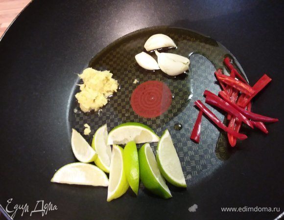 В сковороду (желательно, вок) налить кунжутное масло. Выложить чеснок, имбирь, перец чили и дольки лайма. Добавить табаско по вкусу. 