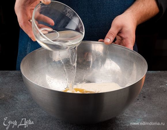 Приготовьте тесто для пиццы. Для этого просейте муку. Добавьте в нее сухие дрожжи, масло, соль и сахар. Все хорошо перемешайте, добавьте 135 мл теплой воды. Перемешайте, Замесите тесто, добавляя постепенно оставшуюся муку. Вымешивайте, пока тесто не перестанет липнуть к рукам. Накройте тесто полотняной салфеткой и поставьте в теплое место на 45 минут.