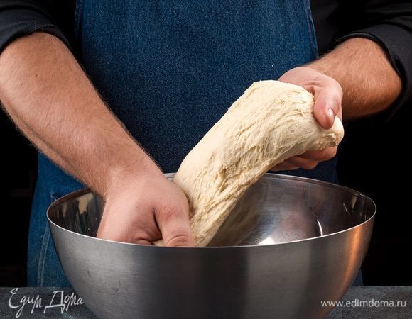 Когда тесто поднимется, вымесите его и растяните в лепешку толщиной 7 мм. Лучше тесто растянуть руками, а не раскатывать скалкой.