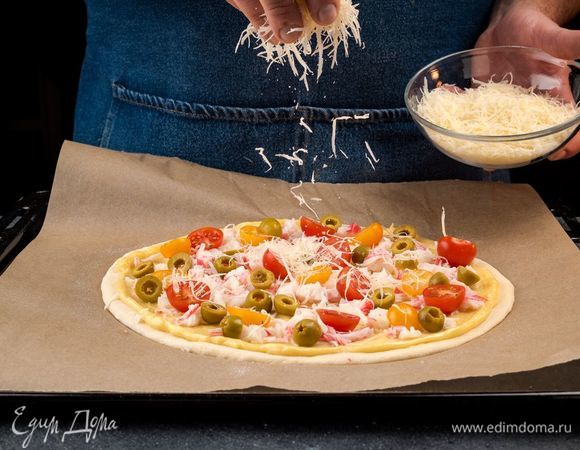 Тесто смажьте майонезом, выложите слоями начинку, а сверху посыпьте сыром.