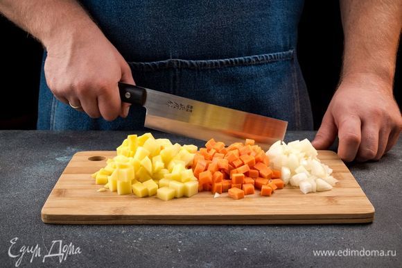 Лук мелко порубите, морковь нарежьте кубиками. Картофель очистите, нарежьте кубиками и залейте холодной водой на 20 минут, чтобы избавиться от лишнего крахмала.