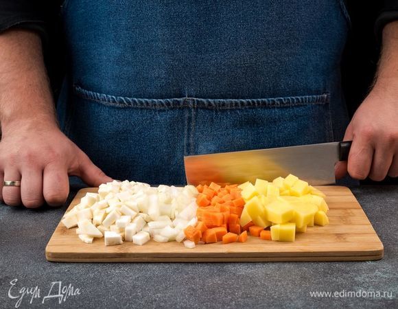 Картофель и лук очистите, нарежьте кубиками, морковь и корень сельдерея также нарежьте. В сковороду налейте оливковое масло и припустите лук, морковь, сельдерей. 