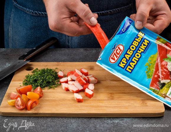 Помидоры черри и крабовые палочки VIČI нарежьте колечками, зелень измельчите. 