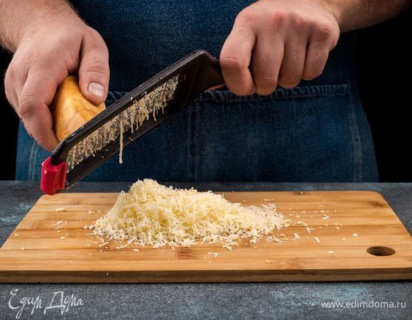 Копченый сыр натрите на терке. Чеснок пропустите через пресс.