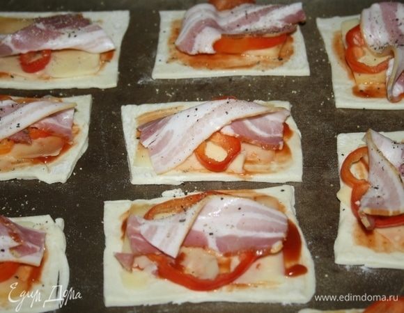 Сверху выложить пластины сыра, ломтики перца, кусочки бекона, приправить черным молотым перцем.