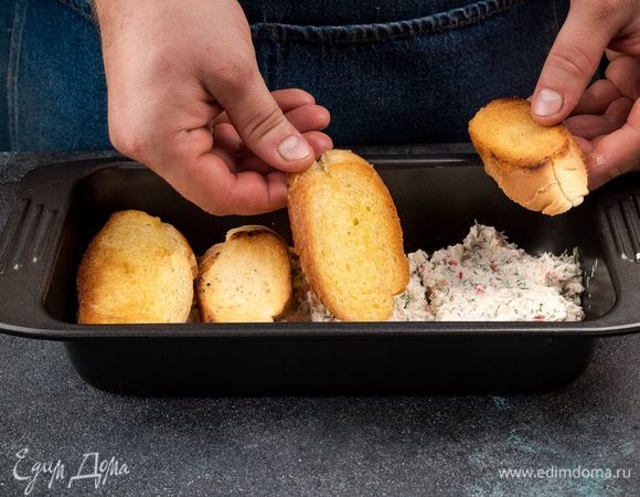 На каждый кусочек багета положите немного начинки, сложите кусочки друг на друга, образуя сэндвичи и выложите в форму. 