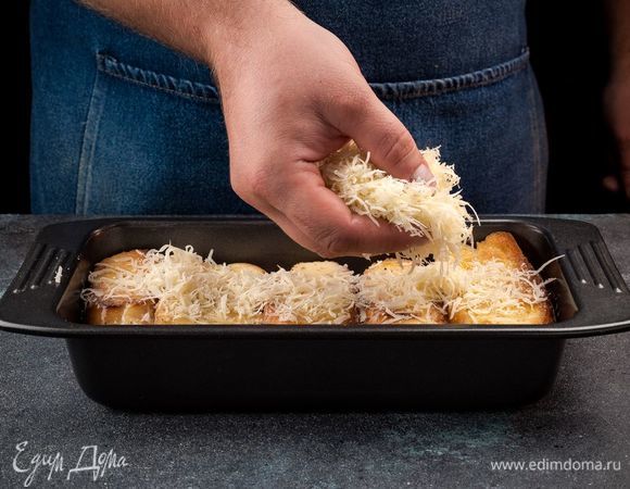 Вылейте заливку на хлеб, сверху посыпьте тертым сыром.