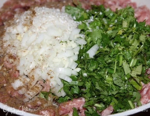 К фаршу добавить промытый рис, нарезанный лук, зелень, перец и соль.