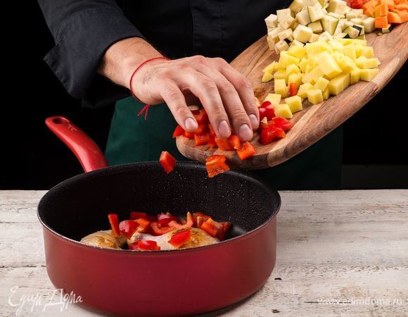 Нарежьте кубиками помидоры, болгарский перец, картофель, морковь и баклажан. Добавьте к мясу нарезанные овощи и неочищенные зубчики чеснока. Перчим и солим.