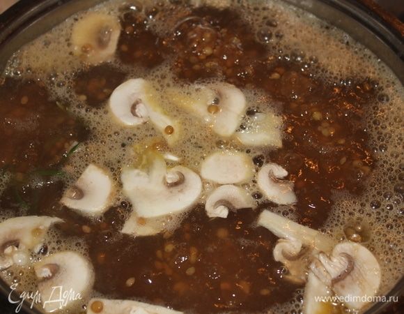 Когда закипит, добавить 1/2 часть порезанных любым образом шампиньонов, порубленный зубчик чеснока, и также можно добавить немного сушеных измельченных грибов. 