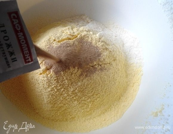 Оба вида муки — кукурузную и высший сорт — просеять в миску. Добавить соль, сахар и сухие дрожжи.