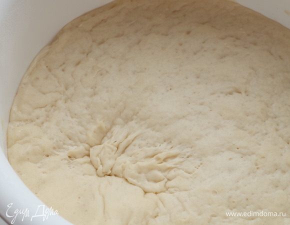 Добавить растительное масло и окончательно вымесить гладкое тесто. Накрыть чашу пищевой пленкой и поставить в теплое место примерно на час. Тесто должно увеличиться минимум вдвое.