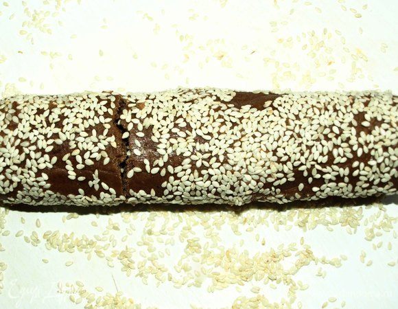 Когда тесто достаточно охладится, то обваливаем его в кунжуте. 