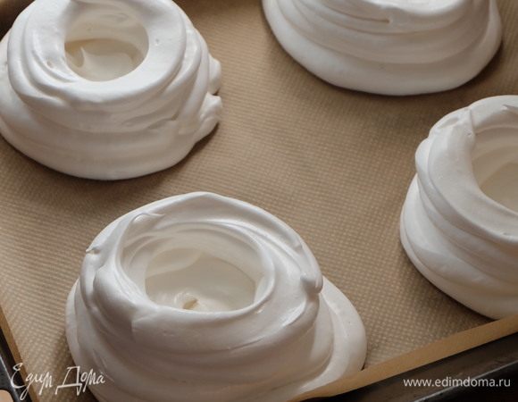 Перекладываем меренгу в кондитерский мешок с круглой насадкой диаметром не менее 1 см. Отсаживаем по кругу «гнезда», то есть делаем подложку, и далее по кругу делаем борта. Если меренга взбита правильно, у вас не должно ничего потечь или деформироваться — абсолютно стабильная масса. Вот на этом фото хороша видна структура правильно взбитой меренги — масса плотная, очень воздушная, прекрасно держит форму.