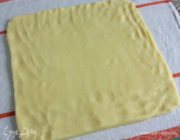 На влажное полотенце выложить картофельную массу и руками или скалкой придать ей форму тонкого пласта 30 х 30 см.