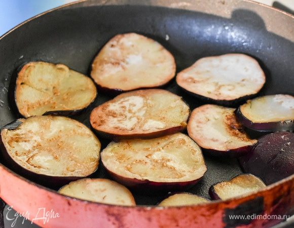 Тем временем приготовим овощи. Баклажан нарежем тонкими кольцами, слегка поджарим на сковороде до легкой румяной корочки.