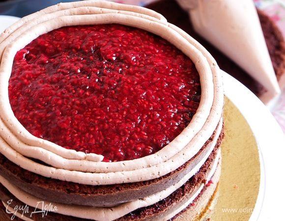 Сверху выкладываем соус — малиновый или черная смородина — на ваше усмотрение. Размазываем ложкой, не церемонясь. Сверху из большого кондитерского мешка с кремом с круглой насадкой по спирали выкладываем крем.