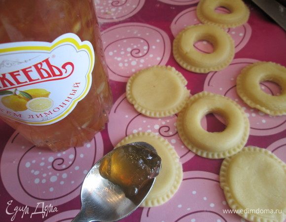 Кружочки толщиной 3-4 мм смазываем тонким слоем лимонного джема ТМ «МахеевЪ». В центре кружочков потолще вырезаем круг. 