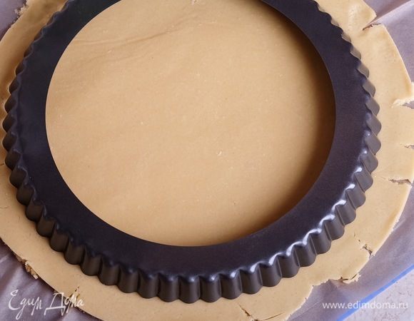 Через пару часов вынимаем тесто из холодильника и раскатываем его между двумя листами пергамента до толщины около 3 мм. Вырезаем круг, который по диаметру будет на 2-3 см больше, чем диаметр формы для выпечки пирога.