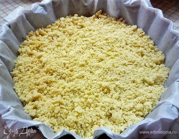 Форму для выпечки выстилаем пергаментом, насыпаем 3/4 теста.