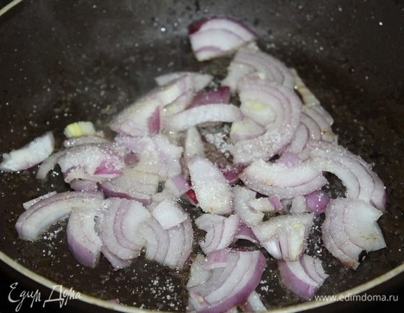 Лук порезать, положить в сковороду, где обжаривалась курица, посыпать его сахаром, готовить около 5 минут.