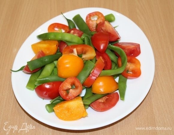 Фасоль отварить в кипящей подсоленной воде 5 минут. Обдать фасоль холодной водой и дать стечь. Помидоры и сладкий перец нарезать небольшими кубиками. Для заправки чеснок пропустить через пресс. Смешать чеснок, соль, перец, винный уксус и оливковое масло.