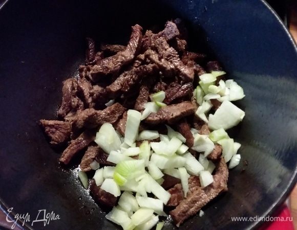 Обжаренное мясо вернуть в жаровню, добавить лук и обжарить 1-2 минуты. 