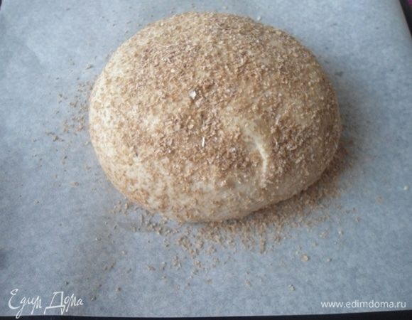 Бумагу для выпечки посыпать отрубями. Тесто немного сбрызнуть водой и тоже посыпать отрубями. (Этот шаг вполне можно опустить, если под рукой нет отрубей). Оставить на 30 минут на расстойку. Духовку разогреть до 170°С.