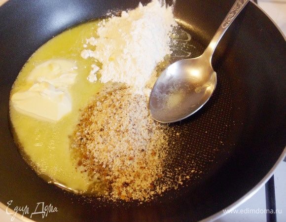 В другой сковороде разогреть оставшееся сливочное масло, положить половину ржаных толченых сухарей, 2 столовые ложки муки и обжарить, помешивая, около 2-3 минут.